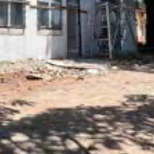 White single-storey building on a cleared site