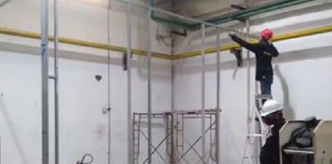 Workers installing metal-stud partition framing and ceiling