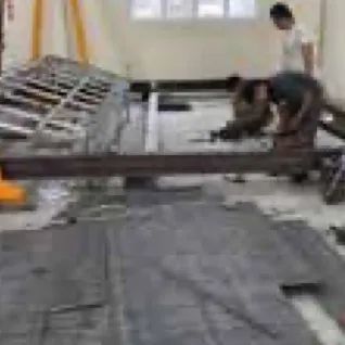 Workers fabricating a steel frame indoors