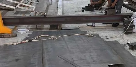 Welding a steel I-beam on the workshop floor